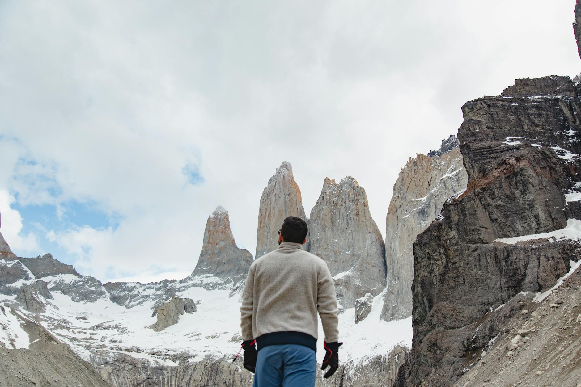 Trekker na szlaku w Torres del Paine z ośnieżonymi szczytami w tle