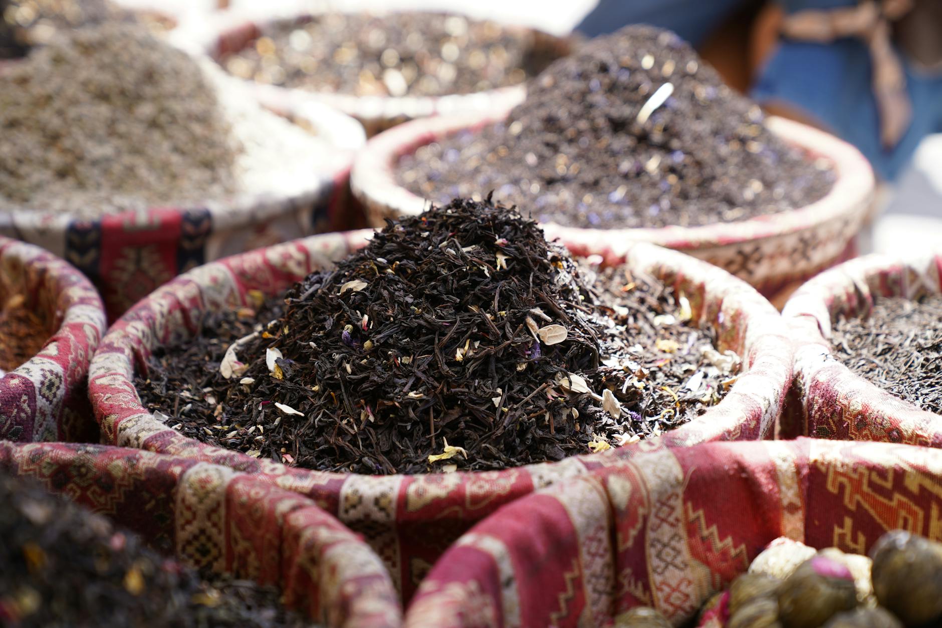 Stragan z kolorowymi przyprawami i ziołami w wiklinowych koszach