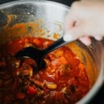 Mieszany ręką gęsty gulasz warzywny z pomidorami w jednym garnku