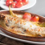 Pieczona ryba z pomidorkami koktajlowymi w glinianym naczyniu