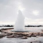 Wybuch gejzeru Strokkur na ośnieżonym islandzkim krajobrazie zimą