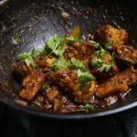 Kurczak w ostrym curry w woku, posypany świeżą kolendrą