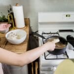 Mama i córka gotują ryż razem na kuchence